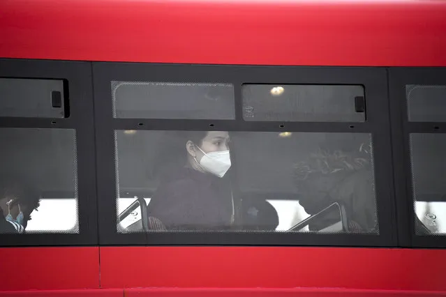 A woman wears a face mask as she sits on a bus, in London, Wednesday, October 7, 2020. Like other countries in Europe, the U.K. has seen rising coronavirus infections over the past few weeks, which has prompted the government to announce a series of restrictions, both nationally and locally, to keep a lid on infections. (Photo by Alberto Pezzali/AP Photo)