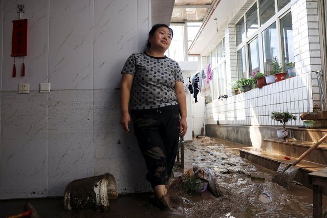 Yan Ping, 43, stands at her mud-covered house as she speaks to Reuters, after heavy rainfall flooded the area in Miyun district of Beijing, China on July 29, 2025. (Photo by Florence Lo/Reuters)