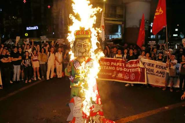 Protesters, mostly students who walked out from their classes earlier, burn an effigy of President Rodrigo Duterte during a rally near the Presidential Palace to call for an “end to President Rodrigo Duterte's rising dictatorship” Friday, February 23, 2018 in Manila, Philippines. The students scored Duterte for the “worsening conditions of politics, the economy and human rights” and are now calling for his ouster. (Photo by Bullit Marquez/AP Photo)