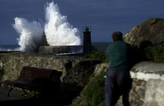 A man looks at waves as they crash against a lighthouse in the port town of Viavelez, Spain, January 18, 2018. (Photo by Eloy Alonso/Reuters)