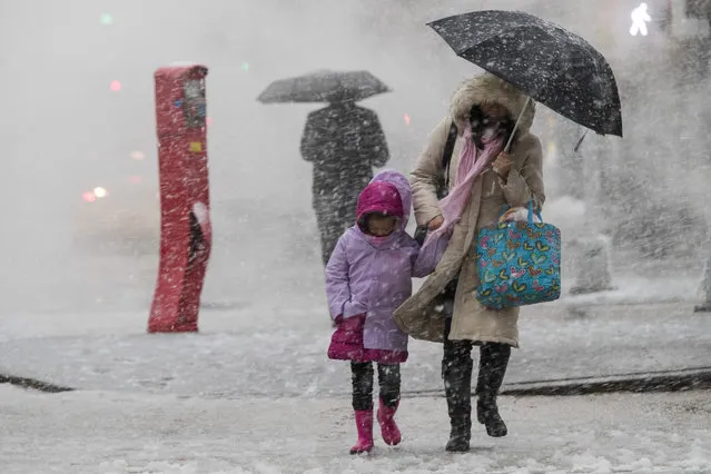 Pedestrians walk along Delancey St. during a snowstorm, Wednesday, March 7, 2018, in New York. The New York metro area was hit with another winter storm Wednesday just days after another nor'easter hammered the region with high winds. (Photo by Mary Altaffer/AP Photo)