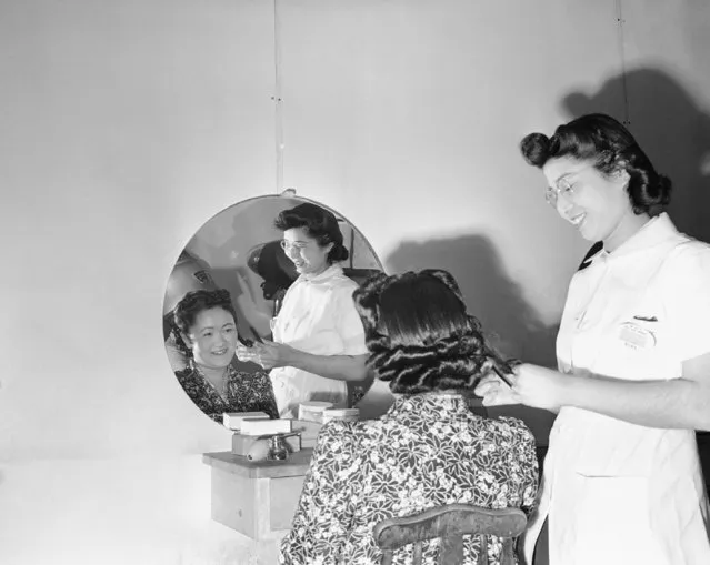 In this May 23, 1943, file photo, Mary Takita of Walnut Grove, Ca, works on the hair of Mrs. Y. Yoshihara of Olympia at the Japanese relocation camp in Tule Lake, Calif., May 23, 1943. As the 75th anniversary of the formal Sept. 2 surrender ceremony that ended WWII approaches, Hidekazu Tamura, a former Japanese-American living in California, has vivid memories of the wartime years he spent in the United States, torn between two nationalities, and the events that led him to renounce his American citizenship and return to Japan. During the pacific war period, Tamura was at Tule Lake, a segregation center for those deemed disloyal, where he joined a group called “Hokoku Seinen Dan,” which means, “Young Men’s Association to Serve the Fatherland”. (Photo by AP Photo/File)