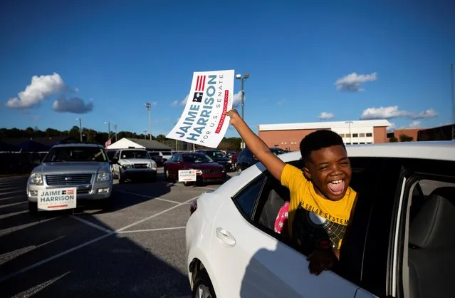A child holds a sign as Democratic U.S. Senate candidate Jaime Harrison holds a drive-in campaign rally at Wilson High School in Florence, South Carolina, U.S. October 24, 2020. (Photo by Sam Wolfe/Reuters)
