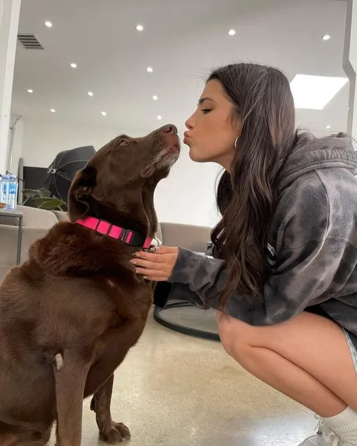 American social media personality Charli D'Amelio in the second decade of February 2023 celebrated Rebel's 9th birthday with a kiss. (Photo by charlidamelio/Instagram)