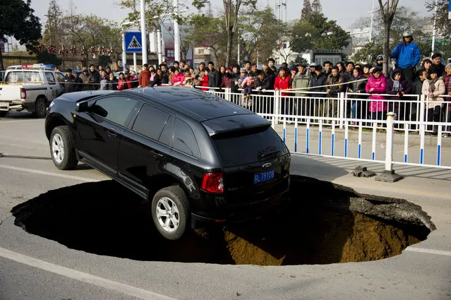 A Ford sedan car halts on the verge of a five meters wide and two meters deep hole at Yunlianghe Road on December 12, 2014 in Zhenjiang, Jiangsu Province of China. A Ford sedan car halted on the verge of a hole at Yunlianghe Road after the road collapsed and formed a five meters wide and two meters deep hole abound 8 o'clock on Friday morning. The road was just opened for two years and the reason is still under investigation.  (Photo by ChinaFotoPress/ChinaFotoPress via Getty Images)