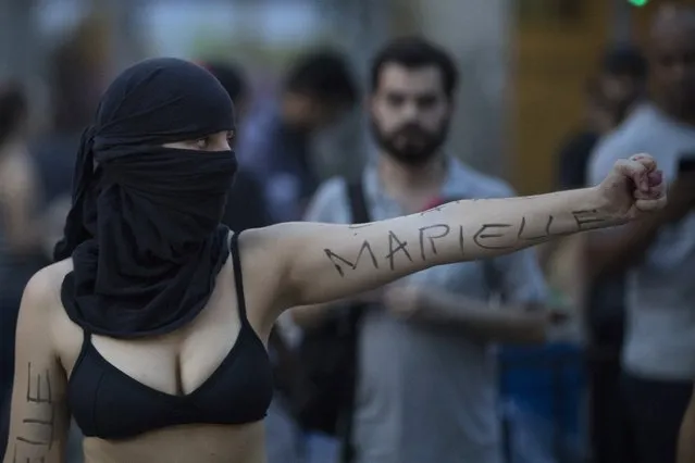 A demonstrator shows her arm with the name "Marielle" written on it, as she performs during a protest against the murder of councilwoman Marielle Franco in Rio de Janeiro, Brazil, Tuesday, March 20, 2018. Franco's murder came just a month after the government put the military in charge of security in Rio, which is experiencing a sharp spike in violence less than two years after hosting the 2016 Summer Olympics. (AP Photo/Leo Correa)