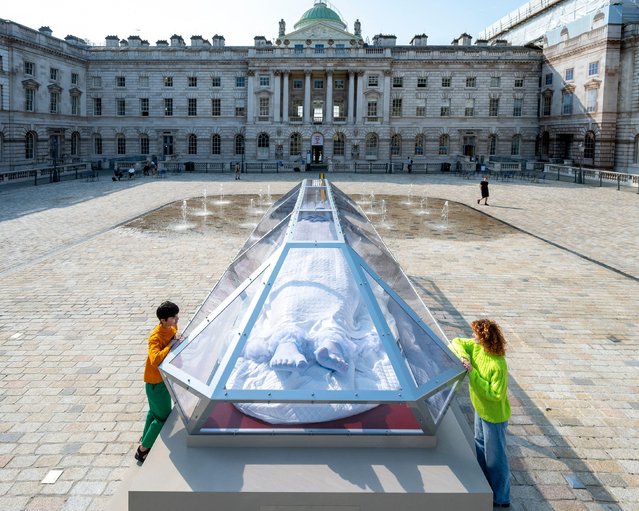 Staff with “The Spell or The Dream” by Turner Prize-winning artist Tai Shani at Somerset House in London, UK on August 6, 2025. The commission celebrates Somerset House's 25th birthday and includes a glowing sculptural figure, Sleeping Beauty, lying within a glass-like vitrine, a 24/7 digital radio station, listening booths, accompanied by a programme of live events. (Photo by Stephen Chung/Alamy Live News)
