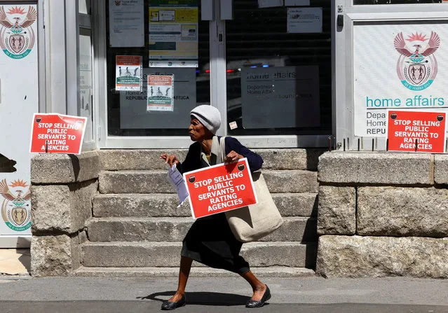 A member of the South African public sector union, National Education, Health and Allied Workers' Union (Nehawu) holds a placard outside the Home Affairs office during a protest over wage disputes and other work issues in Cape Town, South Africa, March 13, 2023. (Photo by Esa Alexander/Reuters)