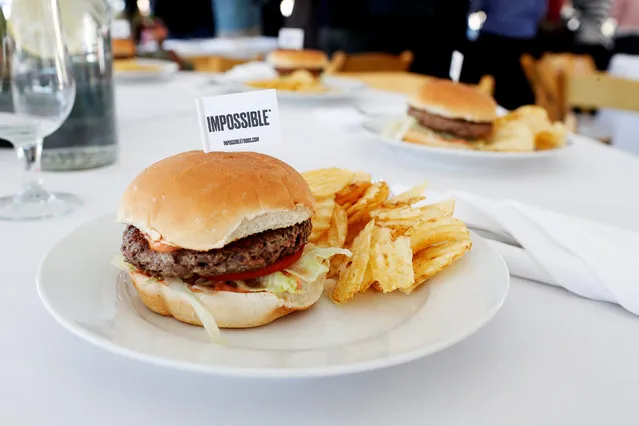 The completed plant-based hamburger is displayed during a media tour of Impossible Foods labs and processing plant in Redwood City, California, U.S. October 6, 2016. It looks like a hamburger, sizzles like a hamburger, and even tastes like a hamburger, but this burger was actually made in a Silicon Valley lab, from plants. “It's a very hard thing to do, but it's doable”, said Patrick Brown of Impossible Foods. The burger is the brainchild of former Stanford professor Patrick Brown. He created Impossible Foods, which recently showed off the fruits of their labor. The burger has more protein, less fat and fewer calories than a lean beef patty and no cholesterol. It also is more environmentally friendly. (Photo by Beck Diefenbach/Reuters)