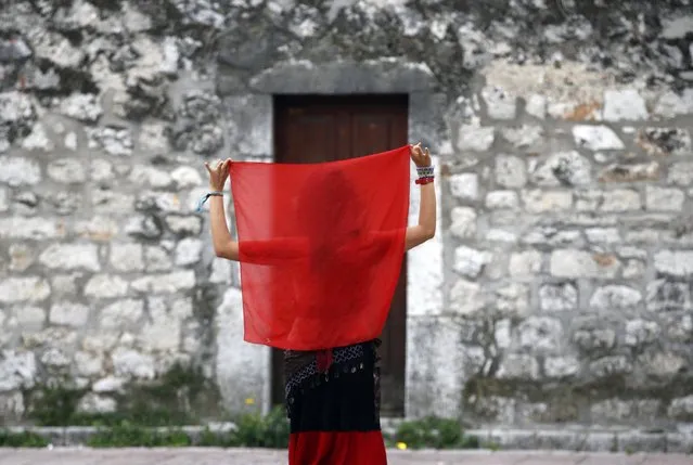 A girl dances on the street in Podgorica, Montenegro, Saturday, October 15, 2016. (Photo by Darko Vojinovic/AP Photo)