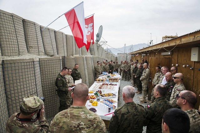 U.S. soldiers from the 3rd Cavalry Regiment take part in a Christmas Eve celebration with soldiers from the Polish army's 21st Mountain Brigade on forward operating base Gamberi in the Laghman province of Afghanistan December 24, 2014. (Photo by Lucas Jackson/Reuters)