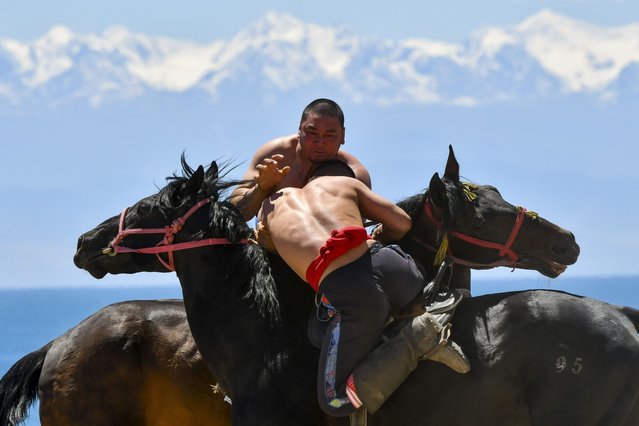 Kyrgyz horse riders compete during a kok boru, also called ulak tartysh, a traditional game in which players on horseback manoeuvre with a goat's carcass and score by putting it into the opponents' goal outside Bosteri village, 202 km, (126 miles) southeast of Bishkek, in the Issyk-Kul Region of Kyrgyzstan, Saturday, June 1, 2024. (Photo by Vladimir Voronin/AP Photo)