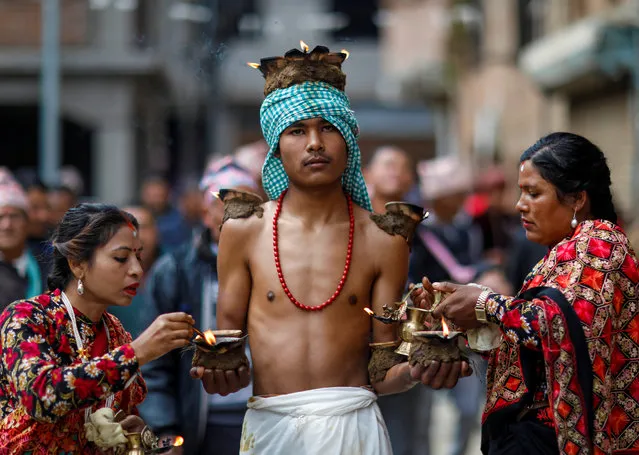 Devotees with lit oil lamps perform religious rituals during the Swasthani Brata Katha festival at Thecho in Lalitpur, Nepal, February 6, 2020. (Photo by Navesh Chitrakar/Reuters)