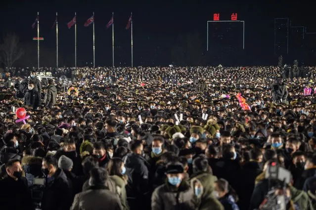 Attendees gather to watch a performance during New Year celebrations at Kim Il Sung square in Pyongyang on January 1, 2021. (Photo by Kim Won Jin/AFP Photo)