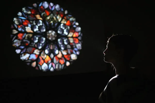 A visitor poses as she views Song for Coal, a large-scale kaleidoscopic projection inside St. Bartholomews Chapel at Yorkshire Sculpture Park on January 8, 2015 in Wakefield, England. The new work by Nick Crowe and Ian Rawlinson explores the physical and cultural properties of coal and its history in the formation of Yorkshire, the landscape and it's people. (Photo by Christopher Furlong/Getty Images)