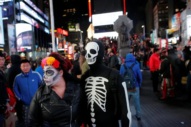 People in costume stand in Times Square on Halloween in Manhattan, New York, U.S., October 31, 2016. (Photo by Andrew Kelly/Reuters)