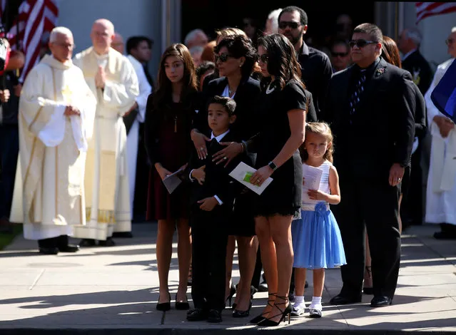 Chief Petty Officer Jason C. Finan's casket is placed in a hearse as his wife, Chariss, and their 7-year-old son, Christopher look on during his funeral in Coronado, California, U.S., November 1, 2016. Finan, 34, was killed October 20 during an offensive to dislodge Islamic State forces from the city of Mosul, Iraq. (Photo by Mike Blake/Reuters)