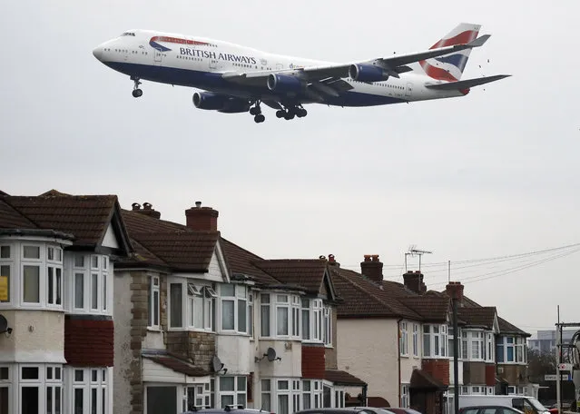 In this Tuesday, Oct. 25, 2016 file photo, a plane flies over nearby houses as it approaches for landing at Heathrow Airport in London. The British Cabinet on Tuesday June 5, 2018, is expected to approve the construction of a third runway at Heathrow Airport, and to put the long-running issue up for a parliamentary vote.  (Photo by Frank Augstein/AP Photo)