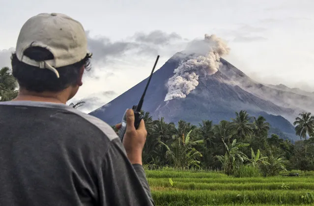 A volunteer uses his walkie talkie as he monitors Mount Merapi during an eruption in Sleman, Wednesday, January 27, 2021. Indonesia's most active volcano erupted Wednesday with a river of lava and searing gas clouds flowing 1,500 meters (4,900 feet) down its slopes. (Photo by Slamet Riyadi/AP Photo)