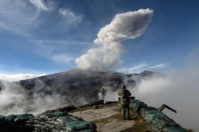 A Colombian soldier watches the Nevado del Ruiz volcano emitting a cloud of ash at Nevado del Ruiz, Caldas Department, Colombia, on May 2, 2023. Colombian authorities recommended, on April 29, 2023, the evacuation of the towns closest to the Nevado del Ruiz volcano in the west of the country, whose seismic activity could trigger an eruption. (Photo by Joaquin Sarmiento/AFP Photo)