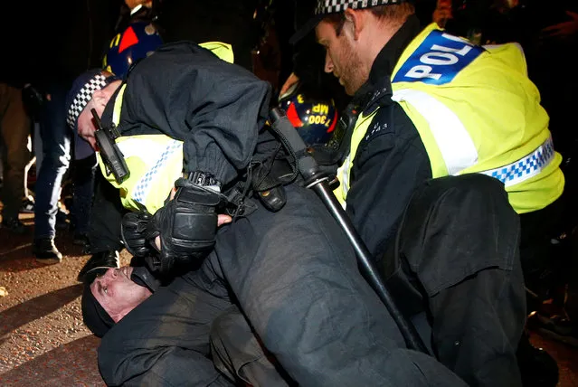 Police officers detain protesters during the “Million Mask March” in London, Britain November 5, 2016. (Photo by Peter Nicholls/Reuters)