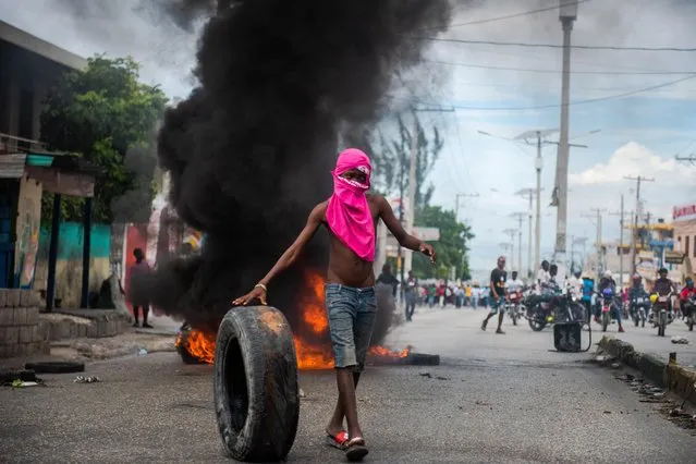 A person demonstrates to demand the resignation of President Moise, who is accused by the opposition of corruption, in the streets of Port-au-Prince, Haiti, 18 November 2020. At least one person has been killed and several injured during two demonstrations against the country's president Jovenel Moise and drafting of a new Constitution, on 19 November 2020. (Photo by Jean Marc Herve Abelard/EPA/EFE)