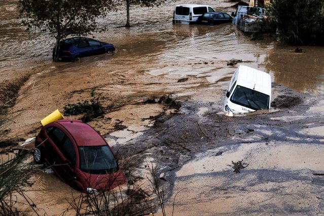 Cars are being swept away by the water, after floods preceded by heavy rains caused the river to overflow its banks in the town of Alora, Malaga, Spain, Tuesday, October 29, 2024. (Photo by Gregorio Marrero/AP Photo)