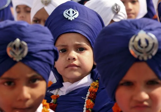 Sikh boys take part in a religious procession on the eve of the 546th birth anniversary of Guru Nanak Dev, the first Sikh Guru and founder of Sikh faith, in Amritsar, India, November 24, 2015. (Photo by Munish Sharma/Reuters)