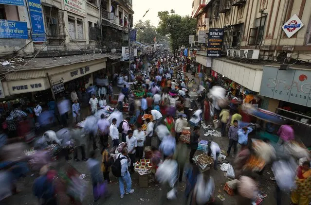 People crowd at a market next to railway station in central Mumbai January 16, 2015. The Reserve Bank of India surprised markets with a 25 basis point reduction in interest rates on Thursday and signaled it could cut further, amid signs of cooling inflation and what it said was a government commitment to contain the fiscal deficit. (Photo by Danish Siddiqui/Reuters)