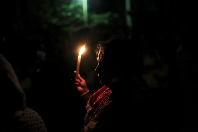 A devotee carries a lit candle to celebrate the Day of the Virgin of Guadalupe outside the Basilica of Guadalupe in San Salvador, El Salvador December 12, 2015. (Photo by Jose Cabezas/Reuters)