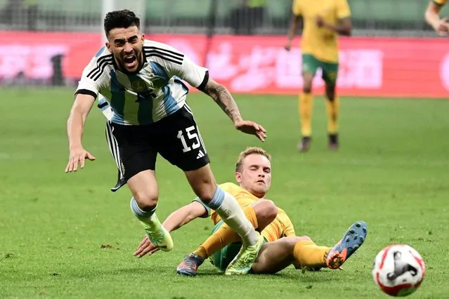 Argentina's Nicolas Gonzalez (L) fights for the ball during a friendly football match between Australia and Argentina at the Workers' Stadium in Beijing on June 15, 2023. (Photo by Pedro Pardo/AFP Photo)