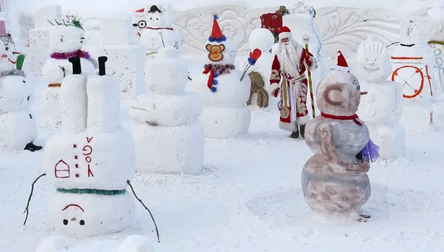 A man dressed as Ded Moroz (Old man Frost or Grandfather Frost), the Russian equivalent of Santa Claus, walks while selecting the best snowman during the festive pre-holiday competition 'Parade of Snowmen' at the Royev Ruchey Flora and Fauna Park on the suburbs of the Siberian city of Krasnoyarsk, Russia, December 20, 2015. (Photo by Ilya Naymushin/Reuters)