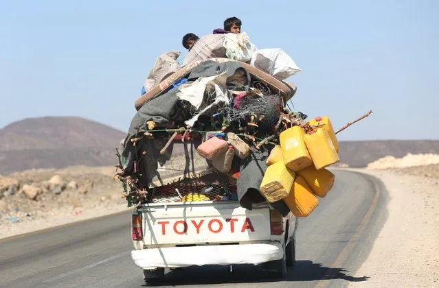 Boys sit on their house belongings as they are transported on a pick-up vehicle while returning home to al-Jadaan area, after the pro-government army retook the area from Houthi rebels, in Yemen's central province of Marib, December 21, 2015. (Photo by Ali Owidha/Reuters)