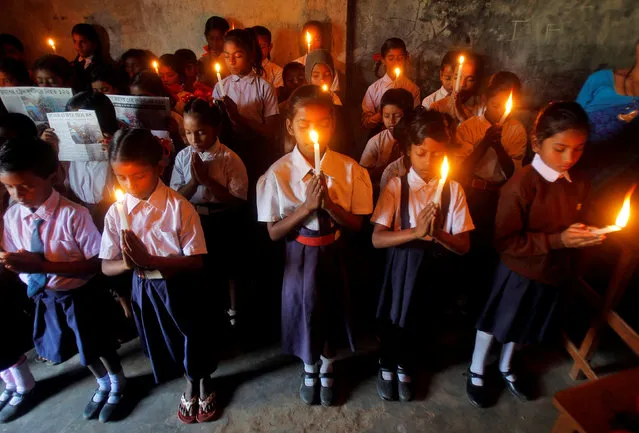 Children hold candles as they pray for the victims of Sunday's train accident at Pukhrayan near Kanpur city,  at a school in Agartala, India, November 21, 2016. (Photo by Jayanta Dey/Reuters)