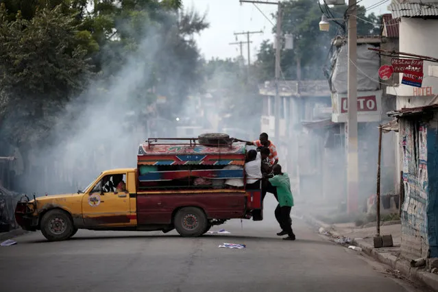 A tap-tap tries to escape from tear gas used by National Police officers to disperse a demonstration of supporters of Fanmi Lavalas political party in the streets of Port-au-Prince, Haiti, November 22, 2016. (Photo by Andres Martinez Casares/Reuters)
