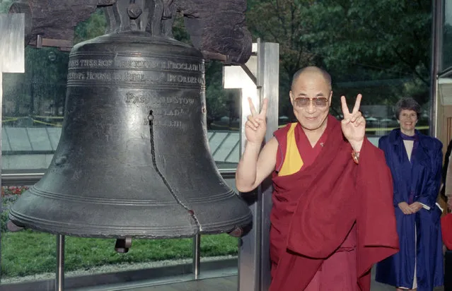 The Dalai Lama, exiled political leader of Tibet, flashes the peace symbol during his visit to the Liberty Bell in Philadelphia on Saturday, September 22, 1990. The Dalai Lama was in town to address students at the University of Pennsylvania. (Photo by AP Photo)