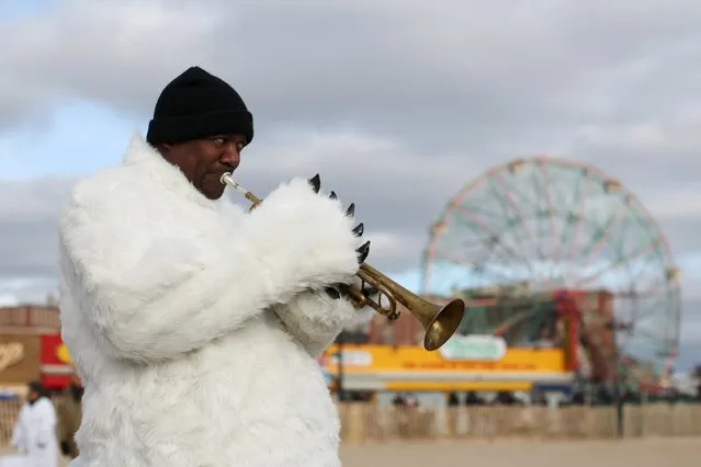 A man in a polar bear costume plays a trumpet before the Coney Island Polar Bear Club's annual New Year's Day swim at Coney Island in the Brooklyn borough of New York January 1, 2016. (Photo by Andrew Kelly/Reuters)
