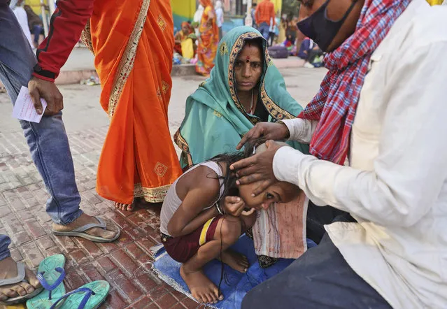 A family get their son head tonsured during Kumbh mela, in Haridwar in the Indian state of Uttarakhand, Monday, April 12, 2021. (Photo by Karma Sonam/AP Photo)