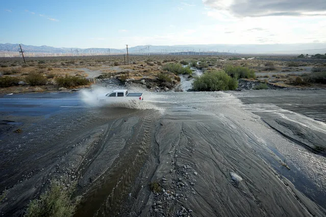 A driver forges Chino Creek, on State Highway 111, a major road leading in and out of Palm Springs, covered with moving water the morning after Tropical Storm Hilary passed Palm Springs, California, U.S., August 21, 2023. (Photo by Bryan Woolston/Reuters)