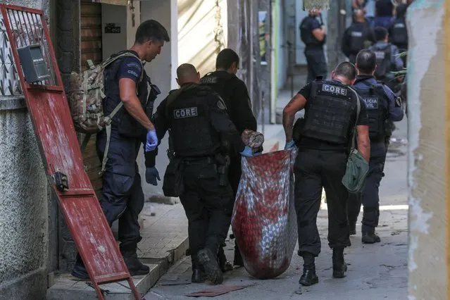 Members of the Police carry a body during a police operation against a gang of drug traffickers, in the Jacarezinho favela of Rio de Janeiro, Brazil, 06 May 2021. At least 25 people died, including a police officer, and another 5 were injured, two of them when they were mobilizing in the subway, during a police operation this 06 May against a gang of drug traffickers in a Rio de Janeiro favela, local media reported. (Photo by Andre Coelho/EPA/EFE)