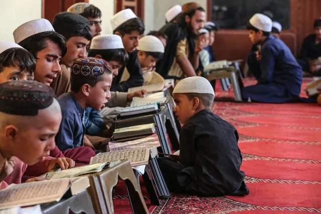 Afghan children read from the holy Quran at a madrassa or an Islamic school in Behsud district of Nangarhar Province on August 28, 2023. (Photo by Shafiullah Kakar/AFP Photo)
