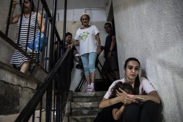 People in Ashdod, Israel take shelter in the stairwell of their apartment building during a siren warning of rockets fired from Gaza to Israel on May 18, 2021. (Photo by Heidi Levine/AP Photo)