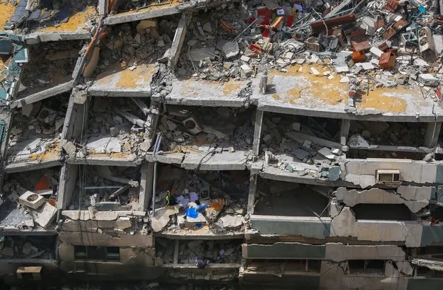 Palestinians inspect the destroyed building housing the offices of The Associated Press and other media, after it was hit last week by Israeli airstrike, in Gaza City, Friday, May 21, 2021. A cease-fire took effect early Friday after 11 days of heavy fighting between Israel and Gaza's militant Hamas rulers that was ignited by protests and clashes in Jerusalem. (Photo by Hatem Moussa/AP Photo)