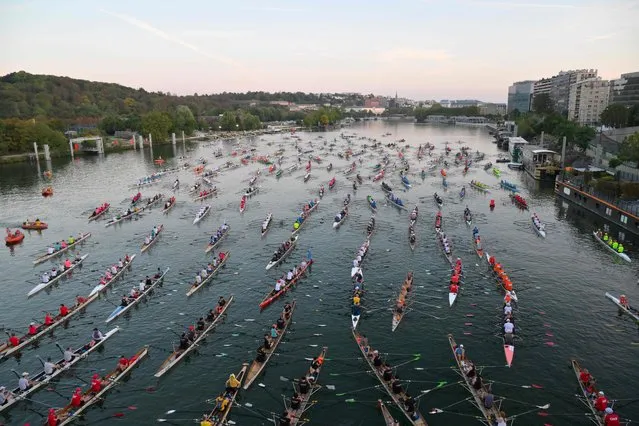 Rowers scull along the River Seine towards the Ile de la Cité, as they participate in the annual “La Traversee de Paris en Aviron” rowing event, that brings together more than 1000 rowers and 230 boats in Paris, on September 10, 2023. (Photo by Miguel Medina/AFP Photo)