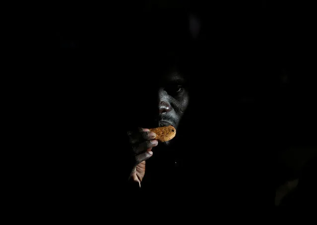 A migrant eats a biscuit on the Migrant Offshore Aid Station (MOAS) ship Topaz Responder after being rescued around 20 nautical miles off the coast of Libya, June 23, 2016. (Photo by Darrin Zammit Lupi/Reuters)