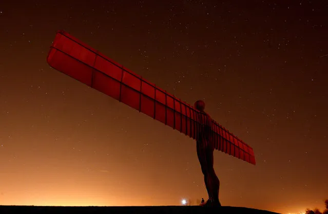 A couple take a photo in front of the Angel of the North in Gateshead, Tyne and Wear as temperatures dropped to near freezing overnight. Picture date: Tuesday October 29, 2013. (Photo by Owen Humpreys/PA Wire)