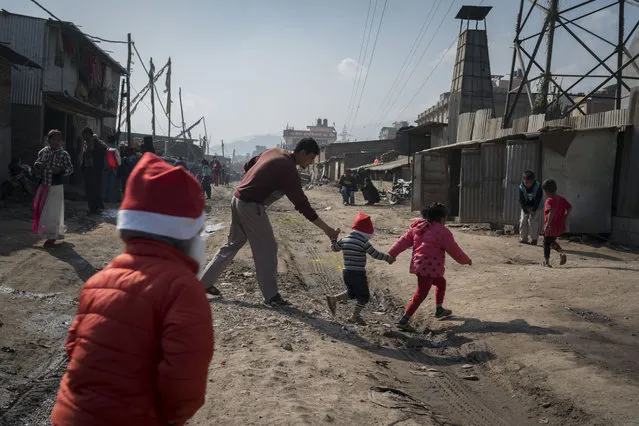 Christian children wearing Santa hats play in a slum area on December 25, 2016 in Kathmandu, Nepal. Many Christians in Nepal celebrate Christmas by copying traditional European Christmas symbols. (Photo by Tom Van Cakenberghe/Getty Images)