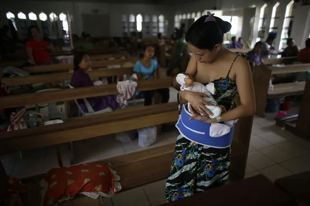 A mother breastfeeds her baby inside a chapel which was turned into a makeshift hospital after Super Typhoon Haiyan battered Tacloban city in central Philippines November 13, 2013. (Photo by John Javellana/Reuters)