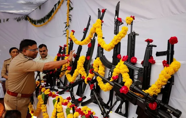 A police officer offers prayer to weapons as part of a ritual at their headquarters on the occasion of Dussehra, or Vijaya Dashami festival in Ahmedabad, India on October 24, 2023. (Photo by Amit Dave/Reuters)