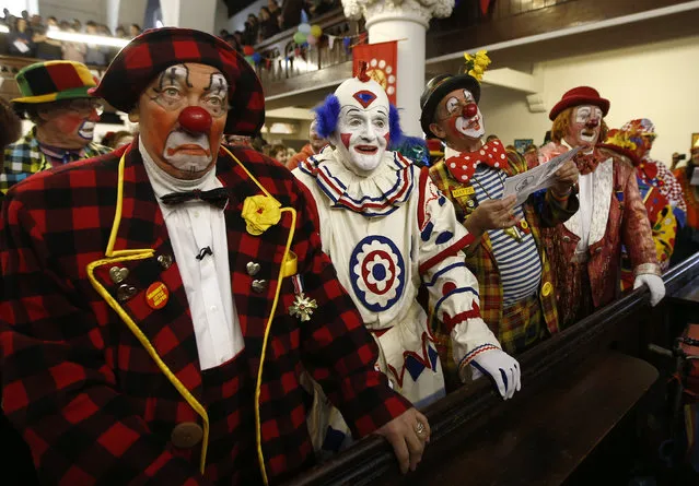 Clowns stand at the pews of the All Saints Church during the Grimaldi clown service in Dalston, north London, February 7, 2016. (Photo by Peter Nicholls/Reuters)